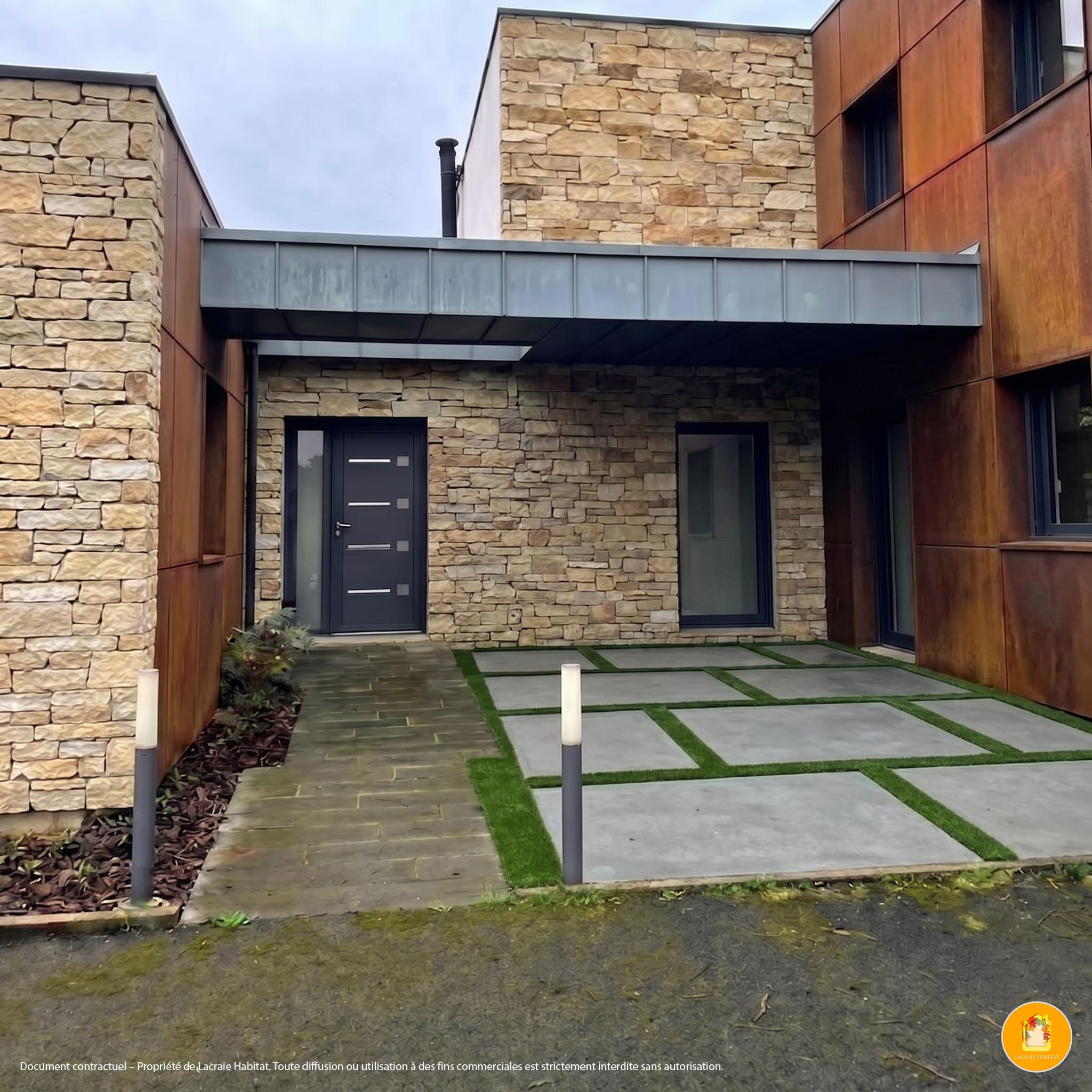Façade rénovée en parement de pierre et cuivre, entrée contemporaine